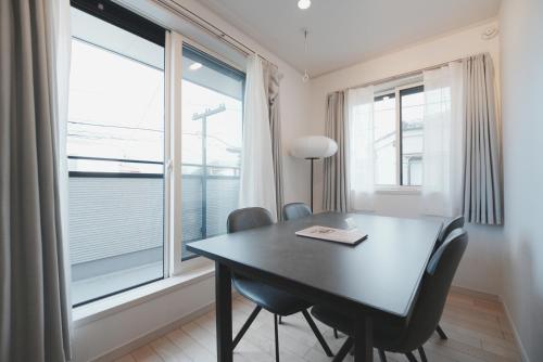 a dining room with a table and chairs and a window at Dorothy Inn Spacious 4LDK New Build 97sqm Up to 10 Guests Free Private Parking Near JR Higashi Jujo Station 3 Minute Walk in Tokyo