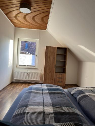 an attic bedroom with a bed and a window at Bückeburg Living in Bückeburg
