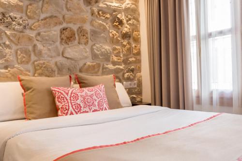 a bedroom with a stone wall and a bed with pillows at Hotel Abaco Altea in Altea