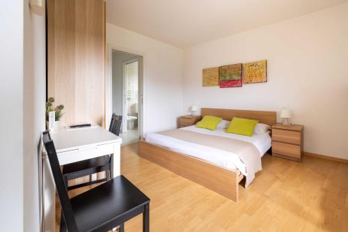 a bedroom with a bed with yellow pillows and a desk at Locanda al Castello in Travesio