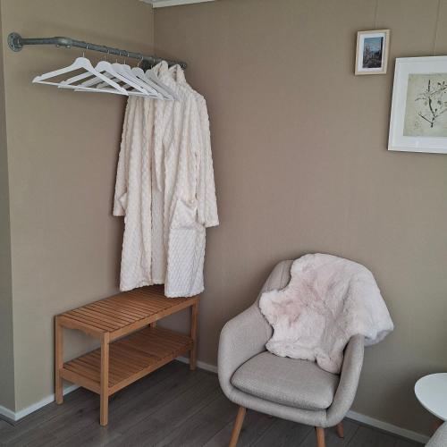 a living room with a chair and a shelf at B en B de 8 Wieken in Oosterwolde