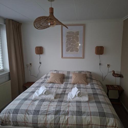 a bedroom with a bed with two towels on it at B en B de 8 Wieken in Oosterwolde