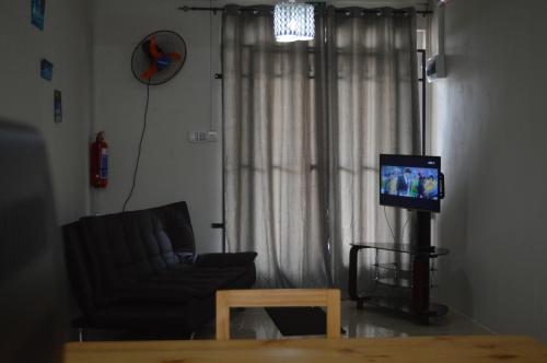 a living room with a couch and a tv at Ashmara Villa & Studio in Flic-en-Flac