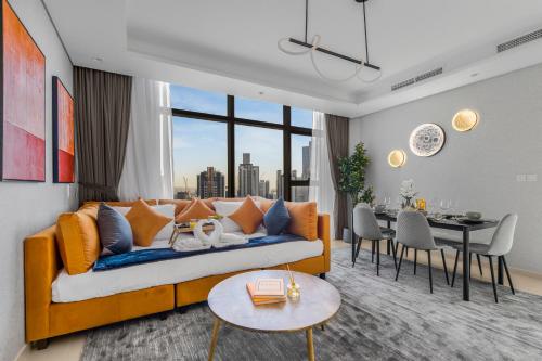 a living room with a couch and a dining room at Luxury Apartments with Rooftop Pool in Paramount Hotel Midtown By Aurora in Dubai
