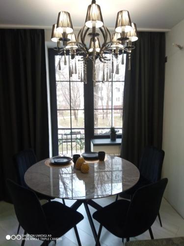 a dining room table with chairs and a chandelier at Balka-centr Tiraspol in Tiraspol