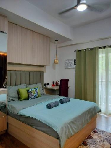 a bedroom with a large bed with two pillows on it at Lauriz Place at Amani Grand Resort and Residences in Lapu Lapu City