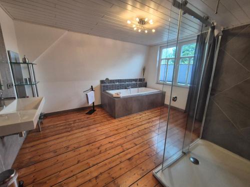 a large bathroom with a tub and a shower at Stadtvilla Norden in Norden