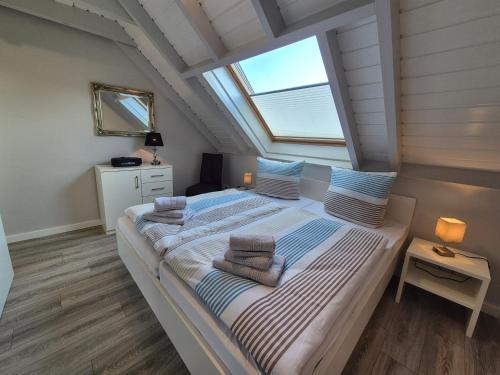 a bedroom with a bed with towels on it at Zauberhaus in Norddeich