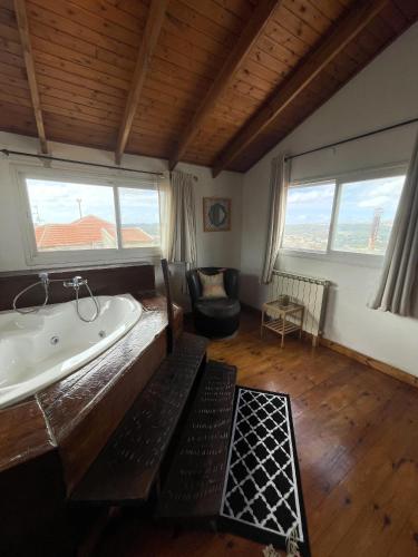 a bathroom with a tub in a room with windows at Nof Harim נוף הרים in Even Menahem