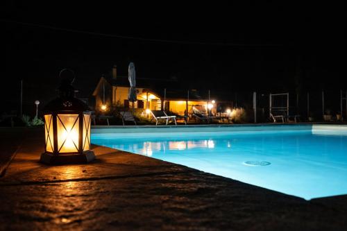 a lighted lantern sitting next to a swimming pool at night at La Casa di Mary in Amelia
