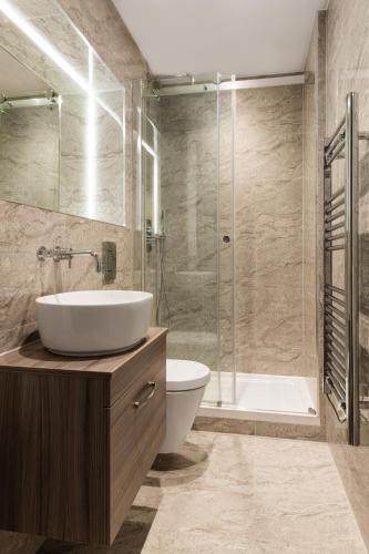 a bathroom with a sink and a toilet and a shower at Abbott House by Viridian Apartments in St. Albans