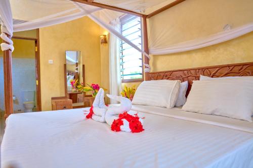 a bedroom with a bed with two stuffed animals on it at Flametree Beach Homes in Diani Beach