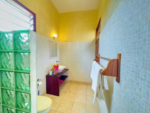 a bathroom with a toilet and a sink at Flametree Beach Homes in Diani Beach
