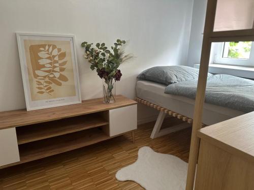 a bedroom with a bed and a vase of flowers at Przytulny Apartament z Balkonem Stalowa Wola in Stalowa Wola