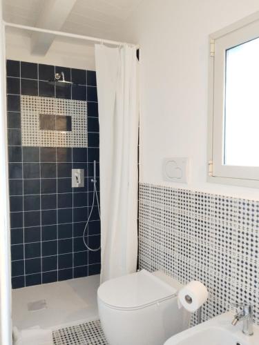a bathroom with a toilet and a sink and a shower at La casa tra le vie in Viagrande