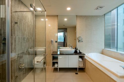 a bathroom with a tub and a sink and a toilet at Hotel Geight Taipei in Zhonghe