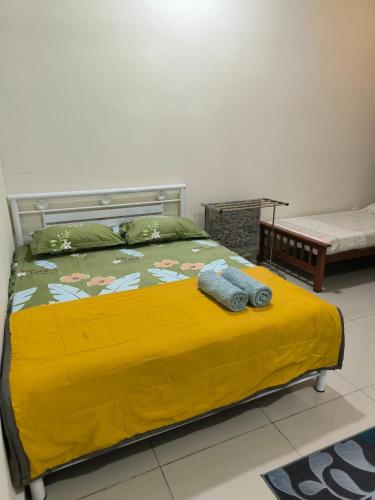 a bedroom with a bed with a yellow blanket at Alieda Homestay 1 Near KLIA in Sepang