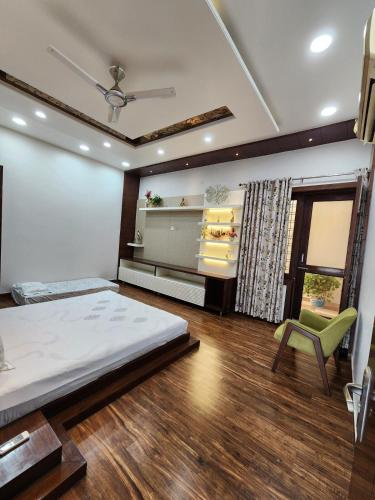 a bedroom with a bed and a chair and a window at The leaf and Hill in Alwar