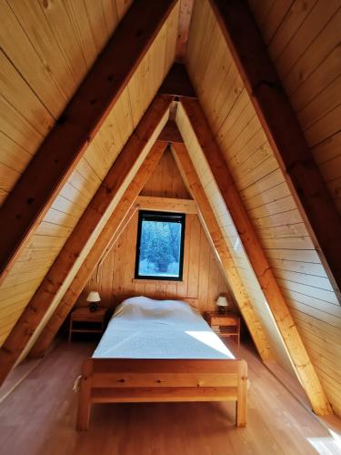 a bed in the attic of a wooden cabin at Chalet du Lioran in Laveissière