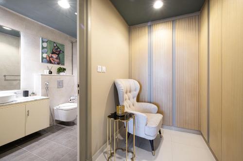 a bathroom with a chair and a toilet in it at Luxury Apartments with Rooftop Pool in Paramount Hotel Midtown By Aurora in Dubai