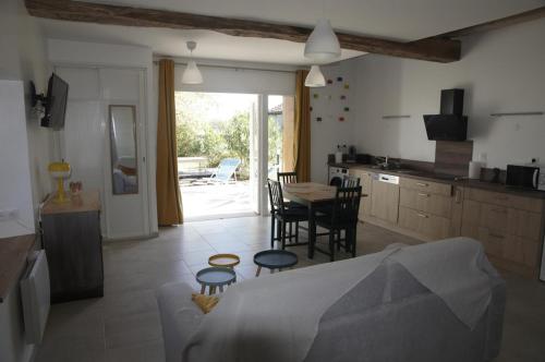 a kitchen and a living room with a table and chairs at Appartement LE CHAI in Saint-Gaudens