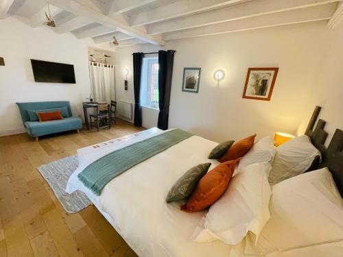 a bedroom with a large white bed with pillows at Ferme les Chapelles Utah Beach in Angoville-au-Plain