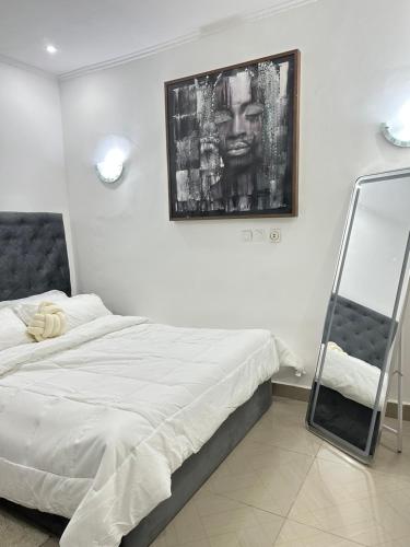 a bedroom with a bed and a mirror on the wall at Bungo Home - Suite Chambre & salon à 2 min de la plage in Pointe-Noire