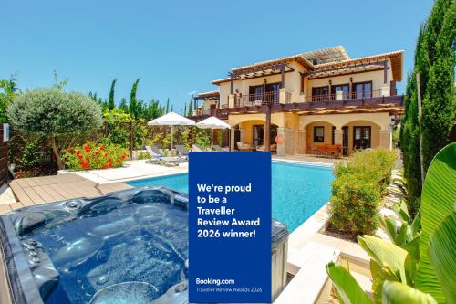 a sign in front of a house with a swimming pool at Luxury Elite Villa AJ06 complete with a private, climate controlled pool and a relaxing outdoor Jacuzzi, Aphrodite Hills Resort in Paphos