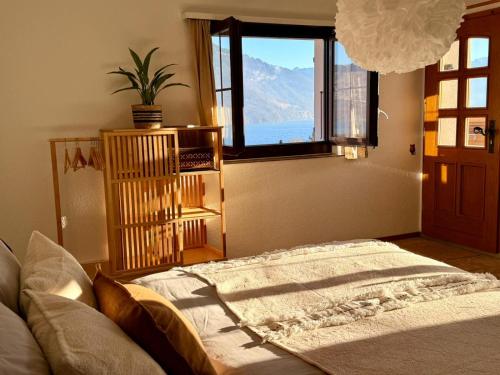 a bedroom with a large bed and a window at Studio Lake View Faulensee in Faulensee