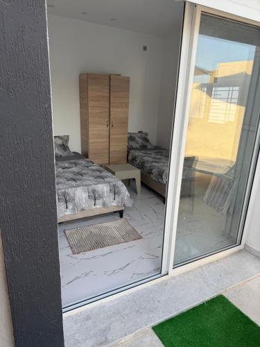 a room with a bed and a sliding glass door at Villa alnaser in Awlād ‘Umar