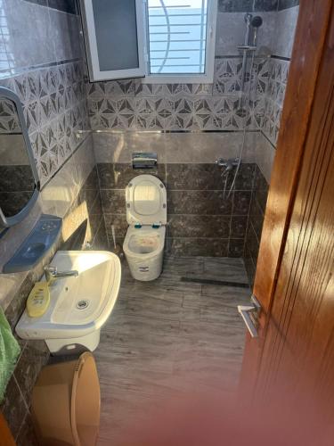 a small bathroom with a toilet and a sink at Villa alnaser in Awlād ‘Umar