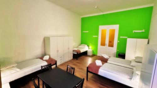 a room with three beds and a green wall at BeBudgetRooms in Budapest