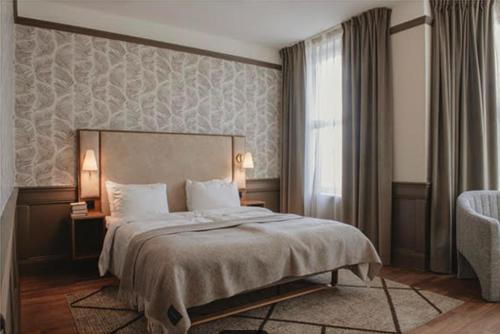 a bedroom with a large bed and a window at Home Hotel Amanda in Haugesund