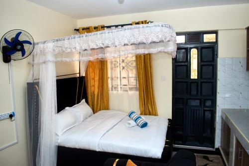 a bedroom with a bed with a canopy and a window at Deluxe Homes 2, Voi in Voi