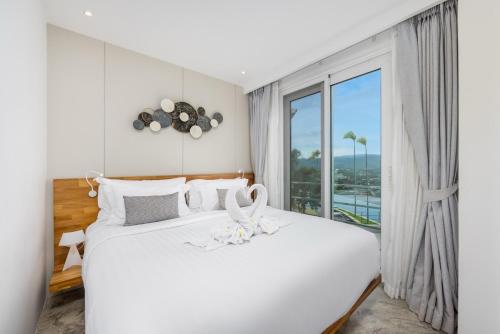 a bedroom with two beds and a large window at UniQue BoutiQue Resort in Bangrak Beach