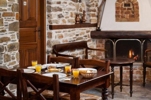 a table with plates of food and a fireplace at Archontiko Papoutsi Pelion in Mouresi