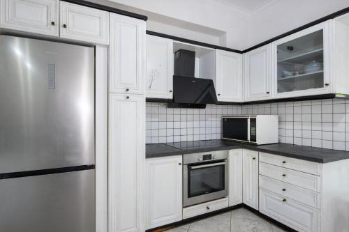 a kitchen with white cabinets and a stainless steel refrigerator at Esperado Gardens Maleme in Maleme