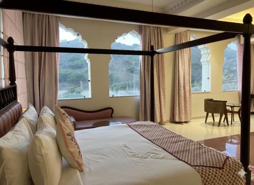 a bedroom with a canopy bed and a living room at Roop Garh Palace, Jaipur in Jaipur