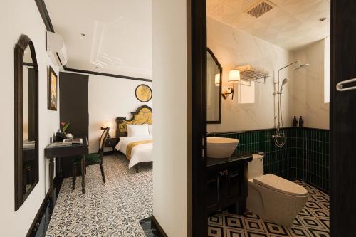 a bathroom with a sink and a toilet and a bed at C'Lau Hotel Ninh Binh - A Gem Nestled in Ancient Quarter in Ninh Binh