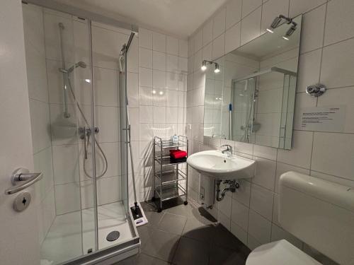 a white bathroom with a shower and a sink at ask rooms Privatzimmer in Kassel in Kassel