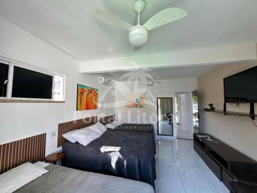 a bedroom with a bed and a flat screen tv at Bangalô MAR & SOL in Saquarema