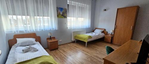 a small room with two beds and a table at NOVA Motel in Międzyrzecz