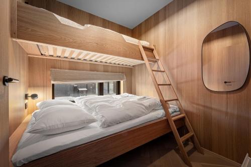a bedroom with a bunk bed with a ladder at New designer cabin in Lofoten in Storøya