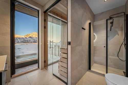 a bathroom with a shower with a view of the ocean at New designer cabin in Lofoten in Storøya