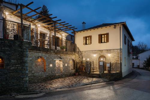 a large stone building with lights on it at Archontiko Papoutsi Pelion in Mouresi