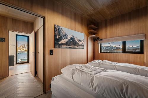 a bedroom with two beds in a room with snow covered mountains at Secluded Lodge - Stunning Views! in Storøya
