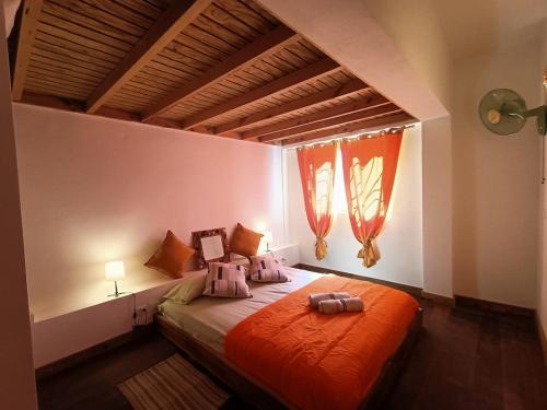 a bedroom with a large bed with an orange blanket at Apartment Mariquita in Las Terrenas