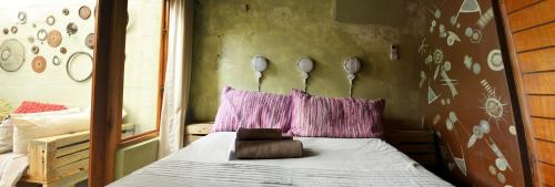 a bedroom with a bed with purple pillows at The Prawn Hatchery Pty Ltd on Amatikulu in Dokodweni