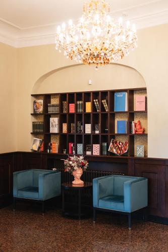 a lobby with two blue chairs and a chandelier at Hotel Jelgava in Jelgava