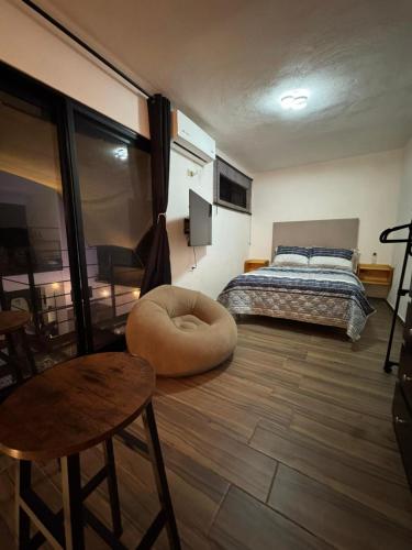a bedroom with a bed and a chair and a table at Serenity Elegance Suite PB in Mérida